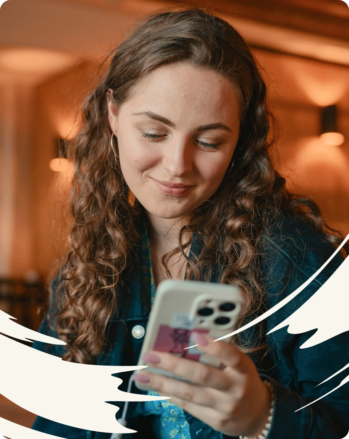 A young woman smiling down at her phone